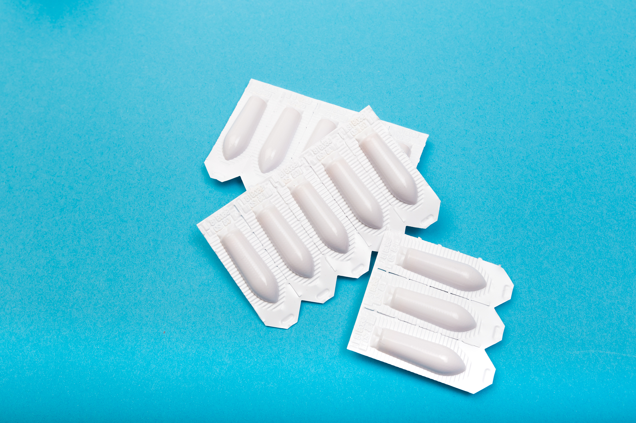 plastic packs of suppositories on blue  background - image