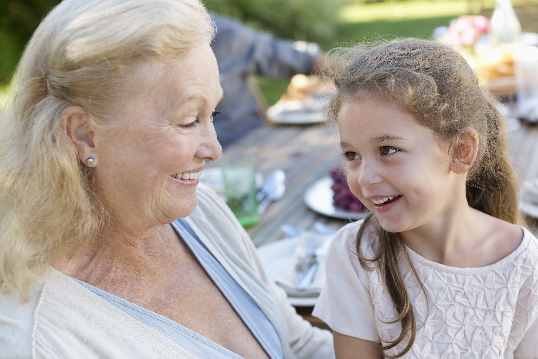 older woman sitting with granddaughter outdoors