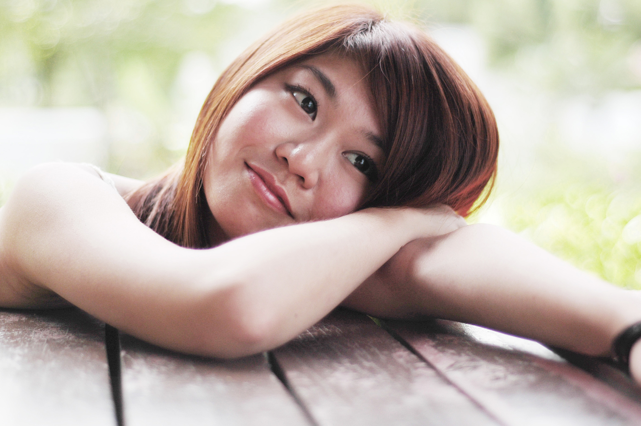 teenage girl resting head on arm, smiling