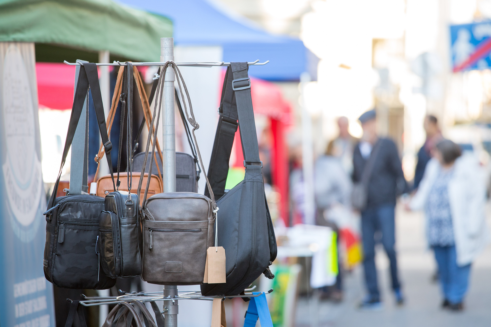 flea market: bags, purse and handbags in the foreground, people 