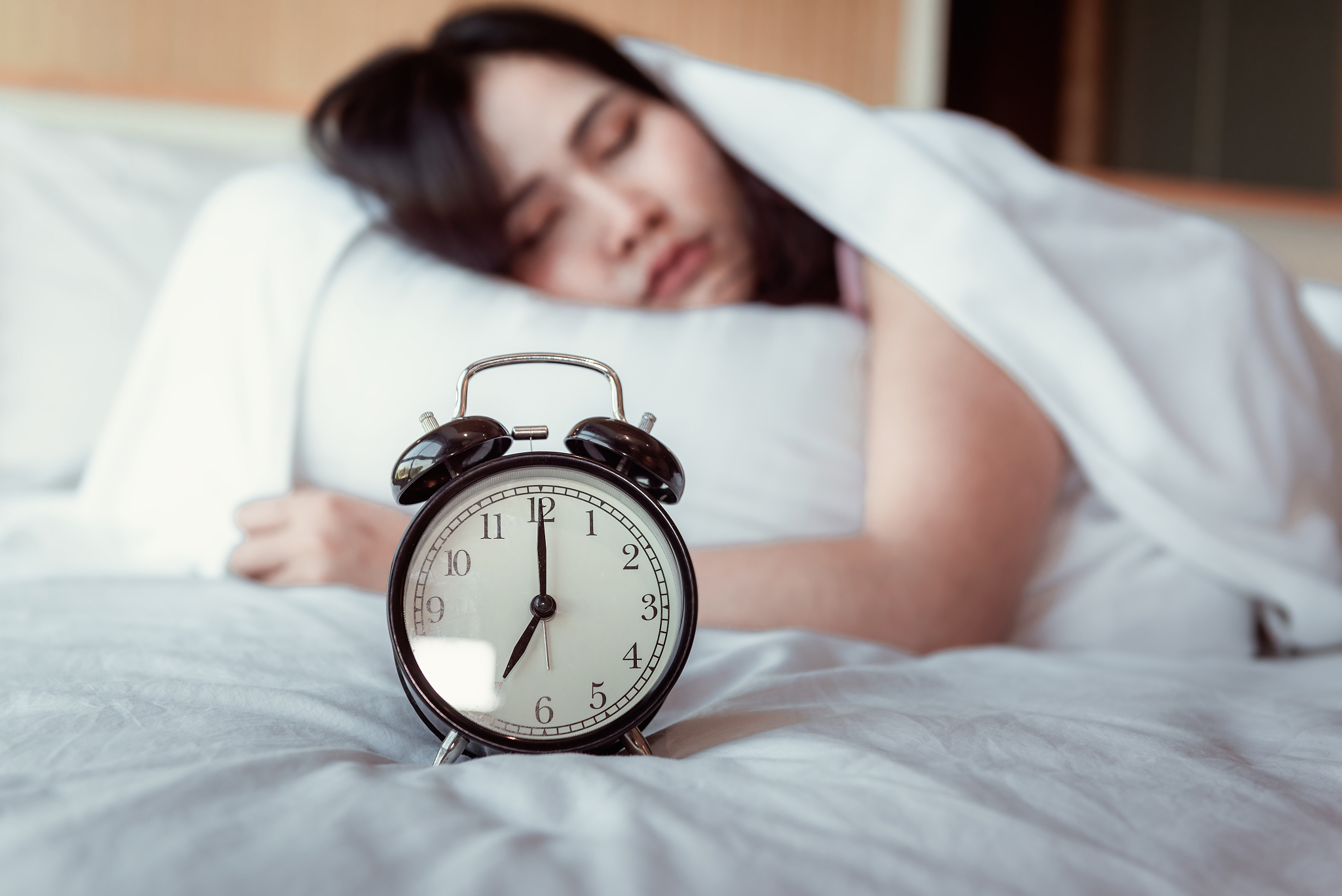 pretty young woman is sleeping and alarm clock in bedroom, beaut