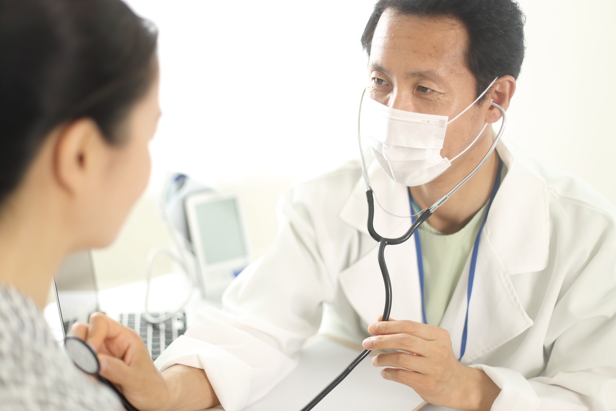 doctor using stethoscope on patient