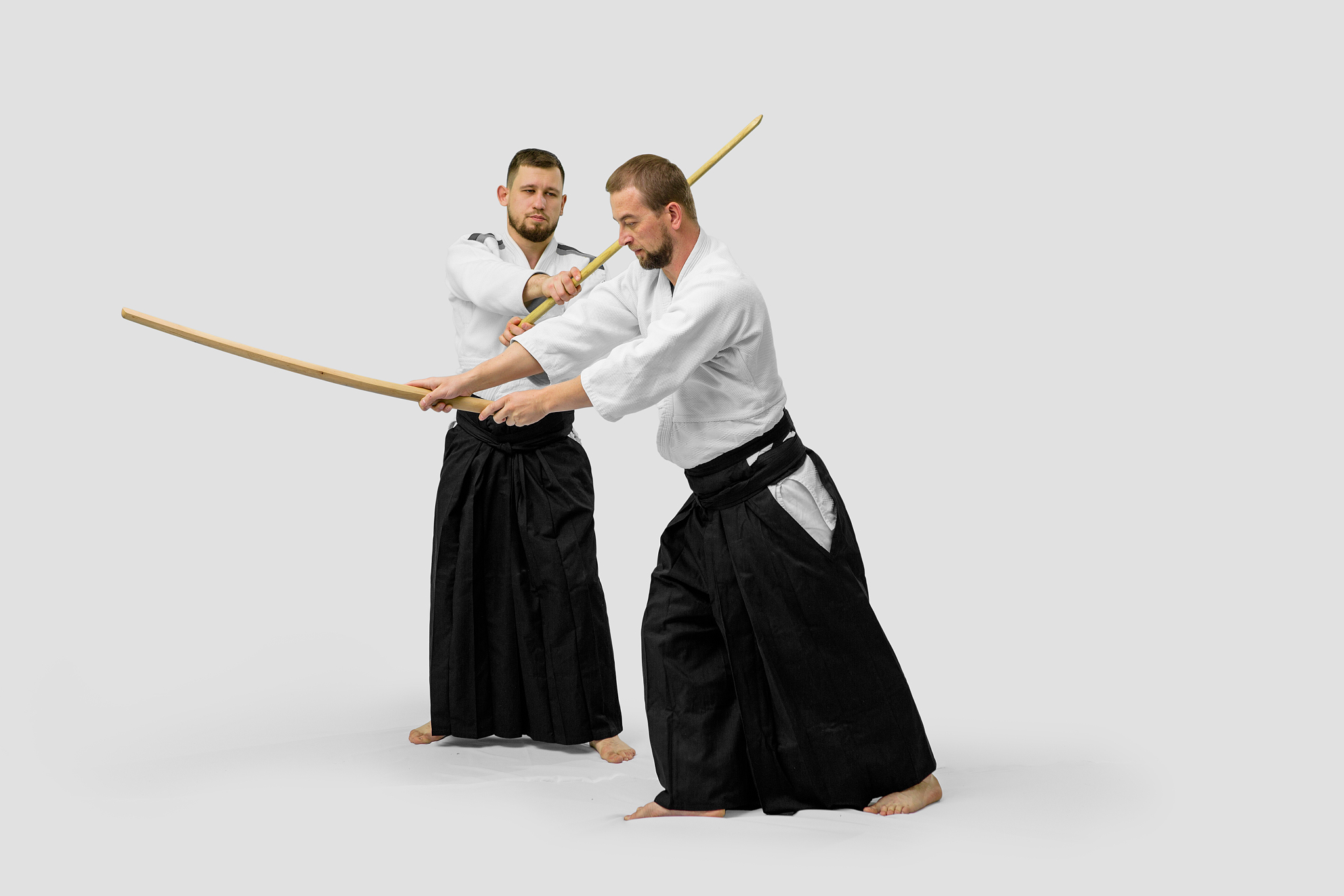 two caucasian men are practicing aikido with bokken (isolation p