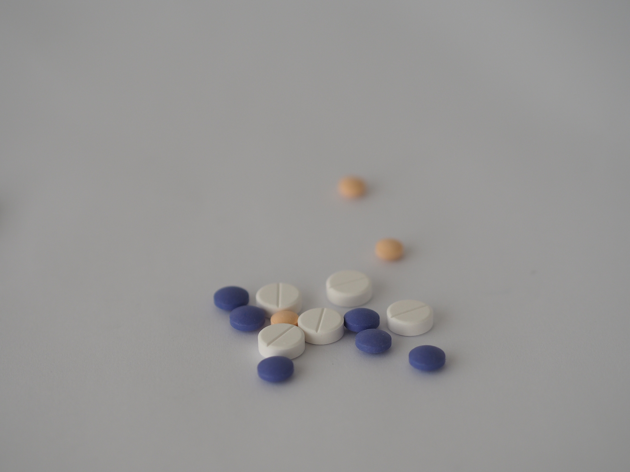tablets pills drugs many color on white paper background