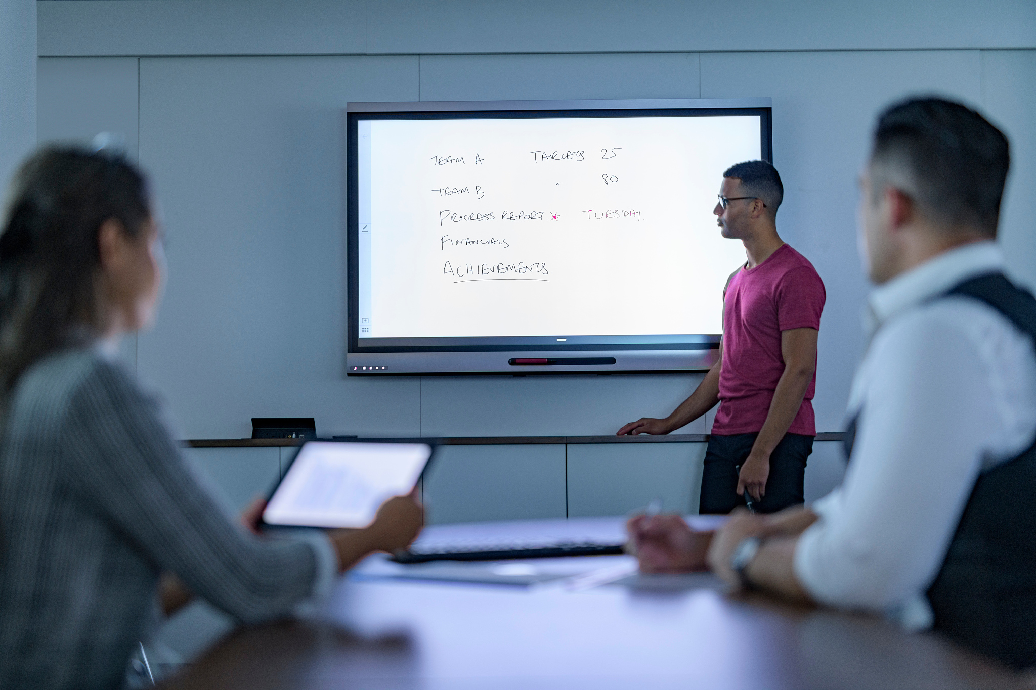 businessman writing on interactive screen in business meeting