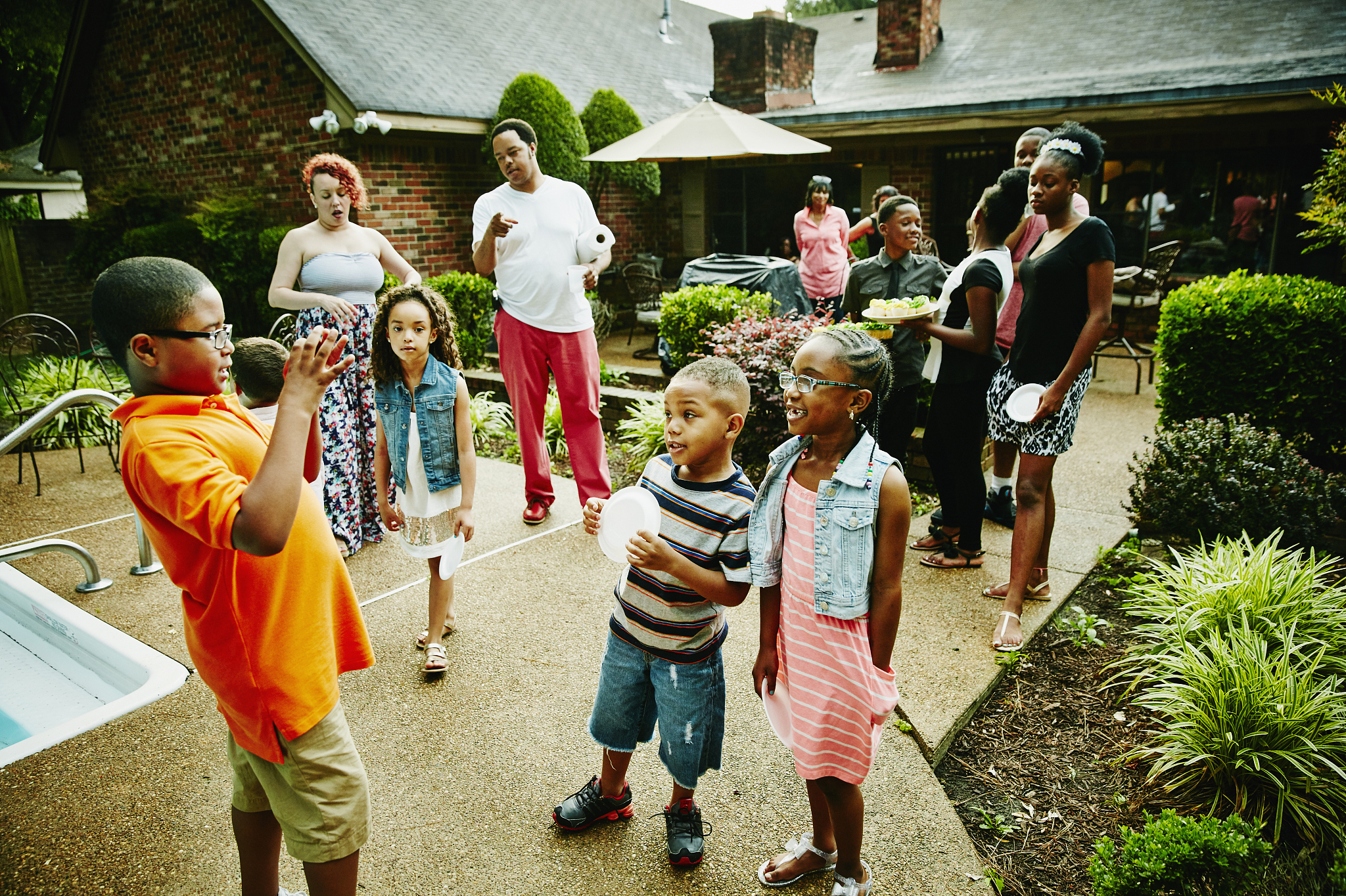 young boy taking photos of cousins with smartphone