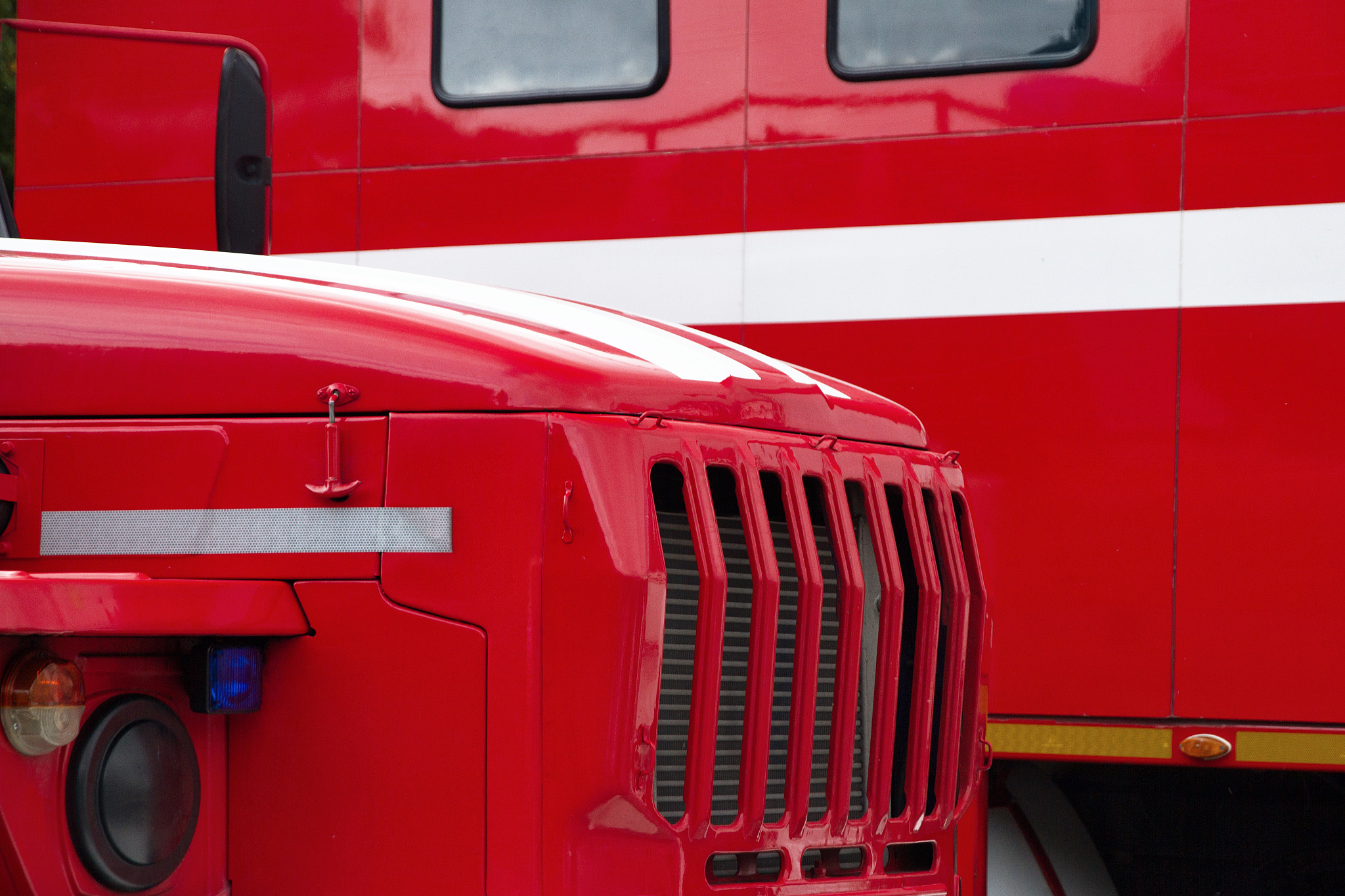 parts of two red fire engines of new cars with a white stripe st