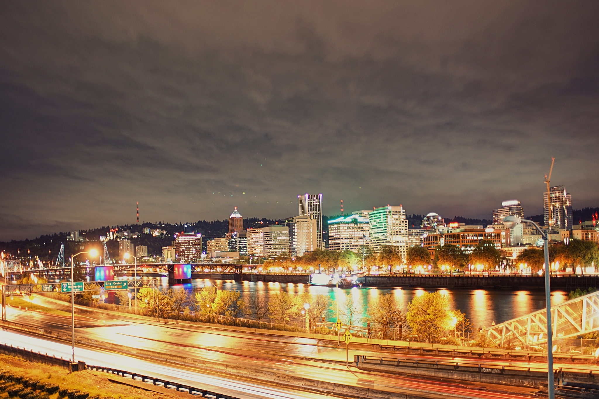 city lit up at night against cloudy sky