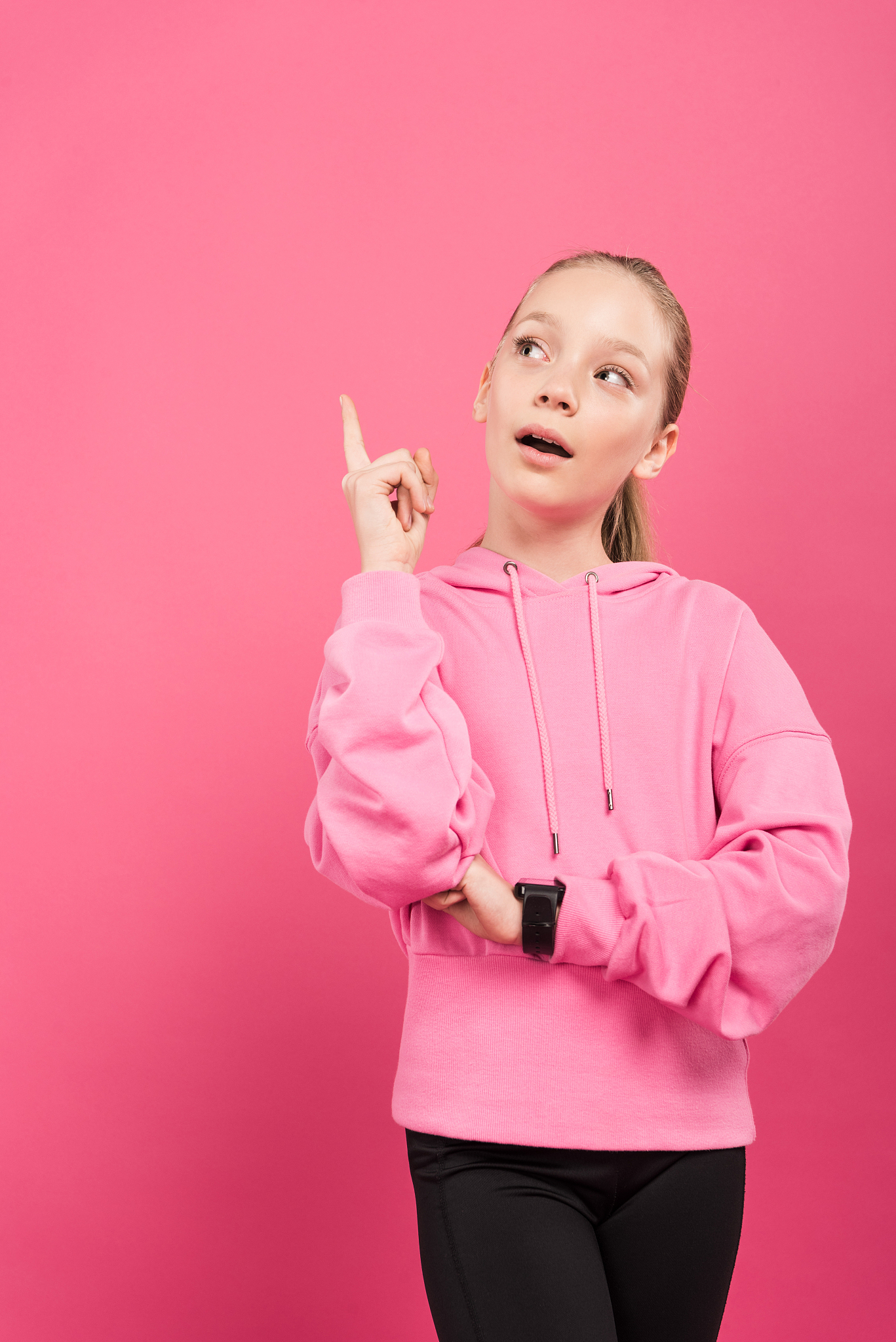 adorable sportive kid pointing up and having idea, isolated on p
