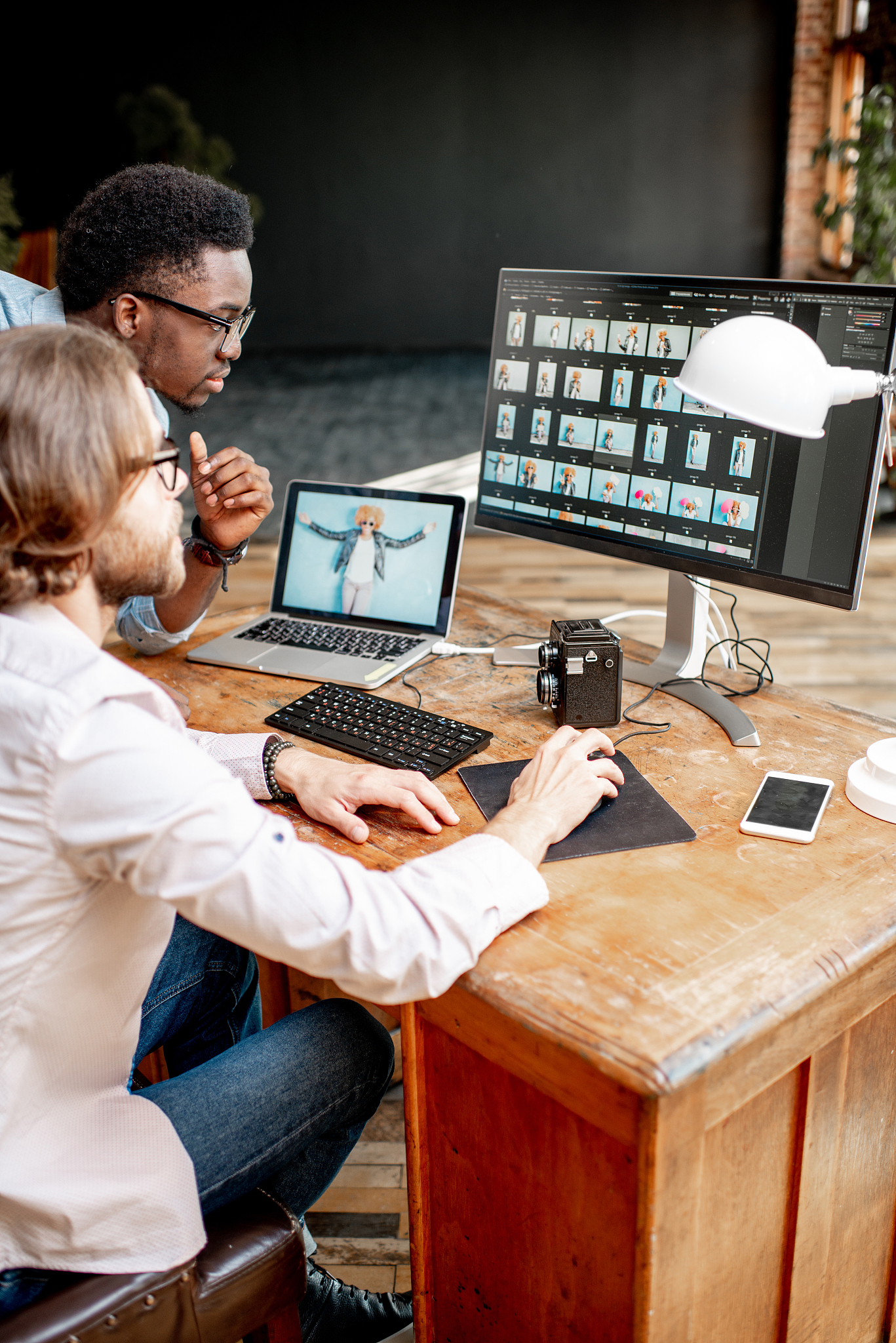 two photographers working on the computers in the studio
