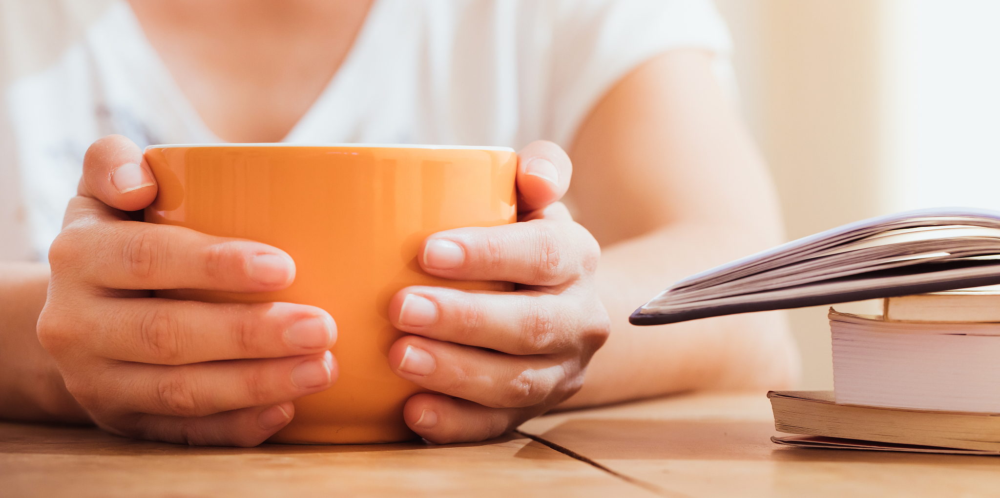 closeup of woman's hands holding orange jumbo mug