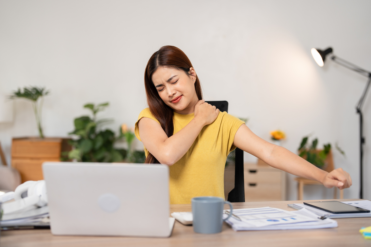 年轻女性手捂肩膀疼痛.办公室综合征与医疗保健概念.,