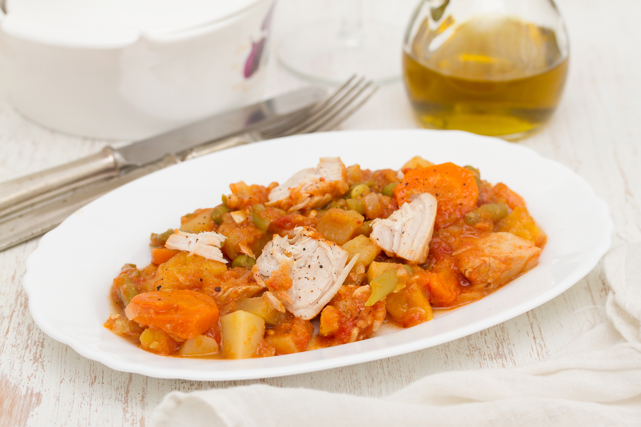 turkey stew with vegetables on white dish on wooden background