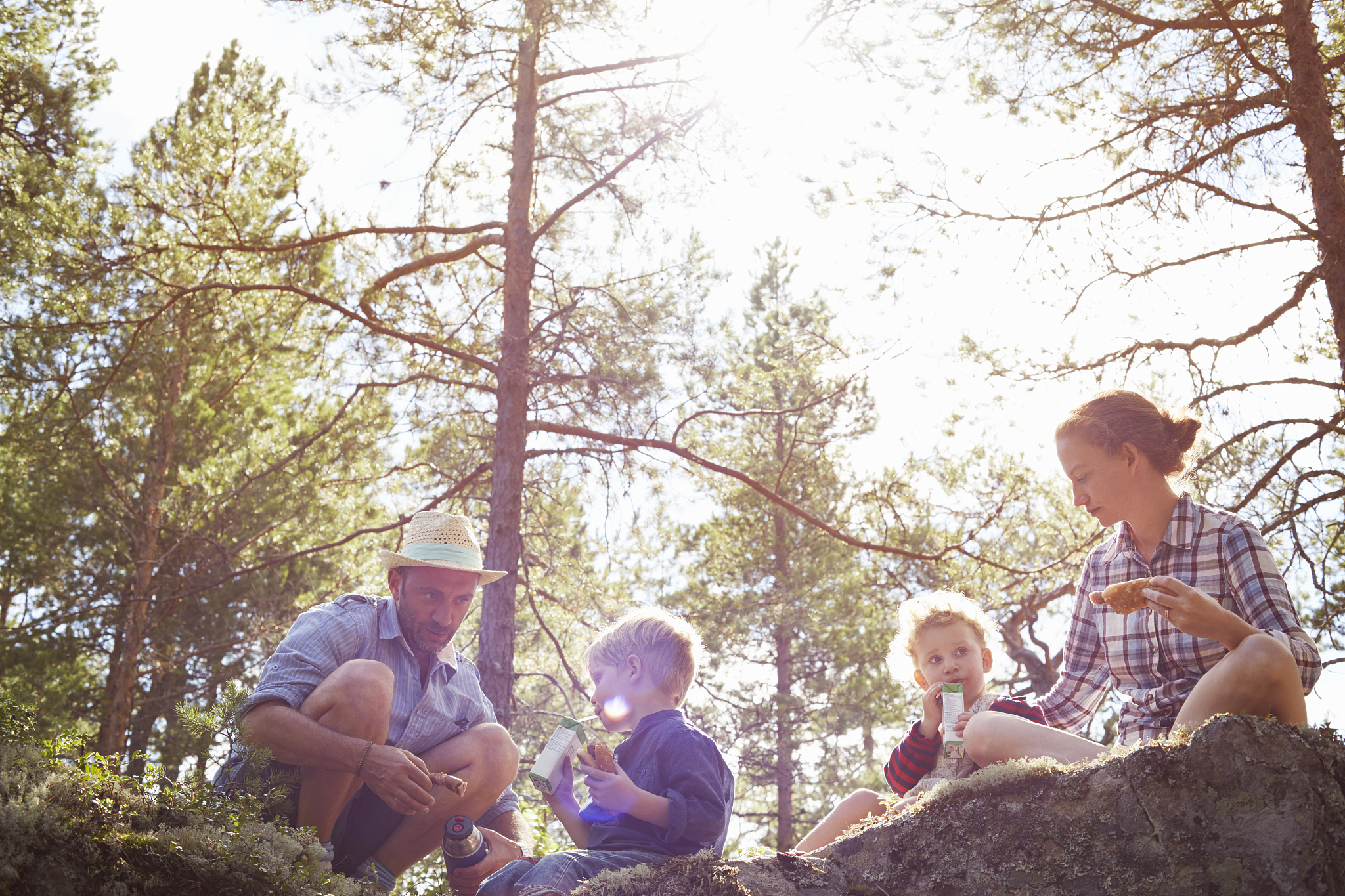 family having picnic sitting on rocks