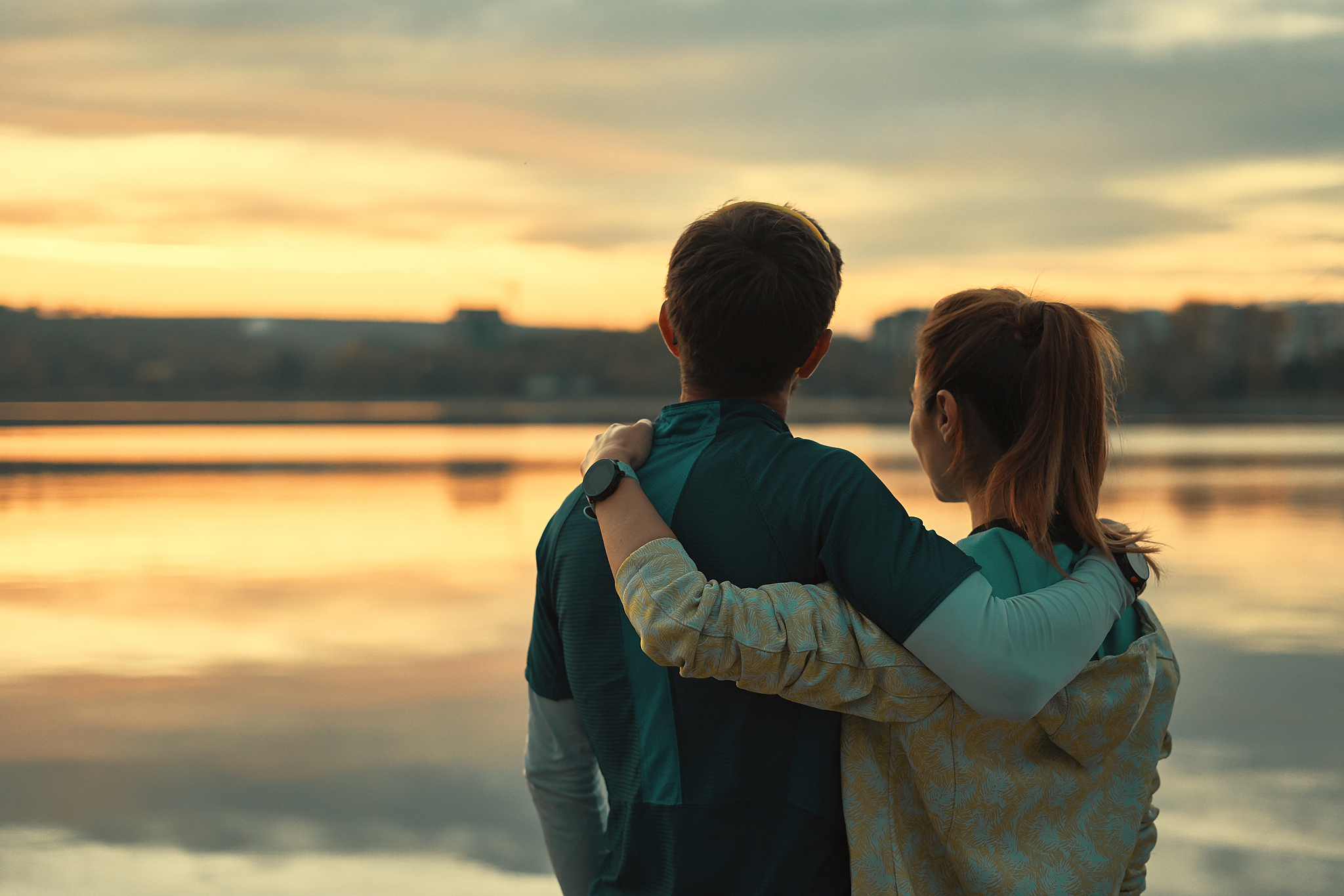 happy romantic fit young couple enjoying sunset