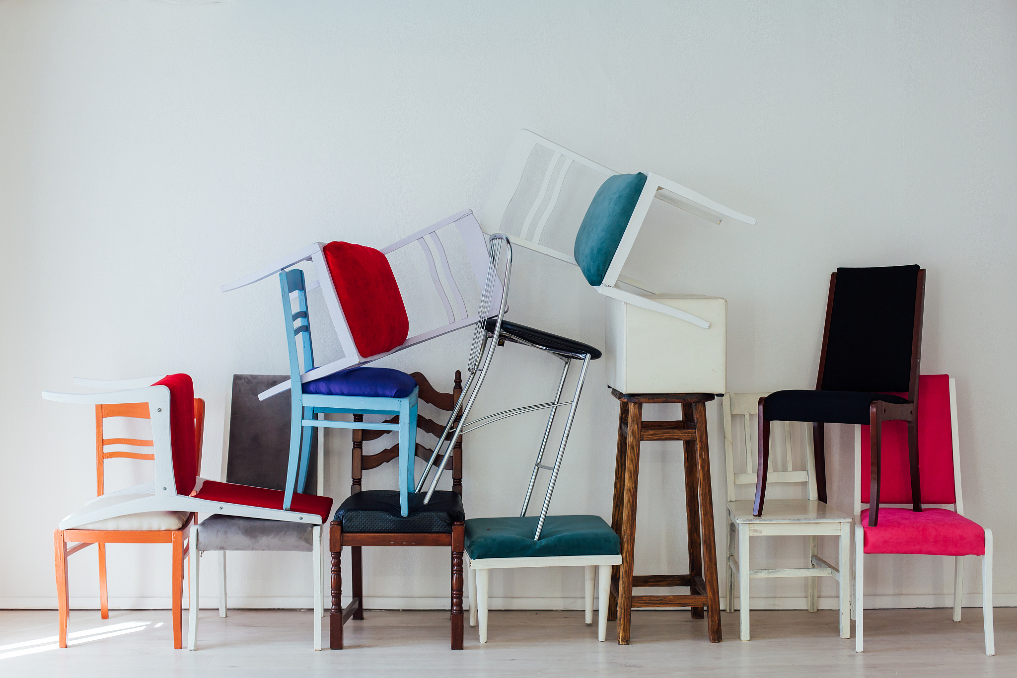 many multicolored chairs stand in the white room