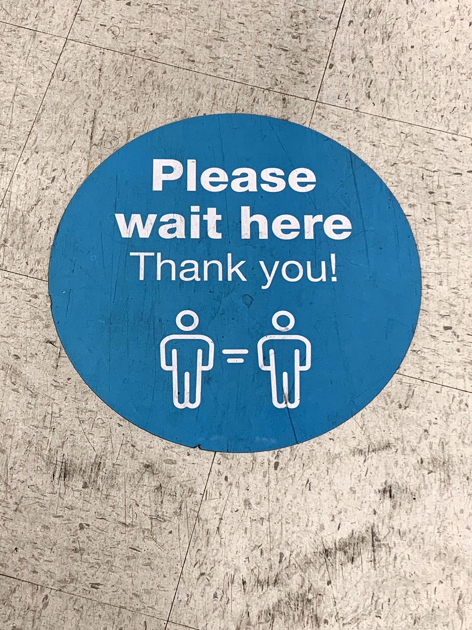 social distancing: information signage adhered onto a store's fl