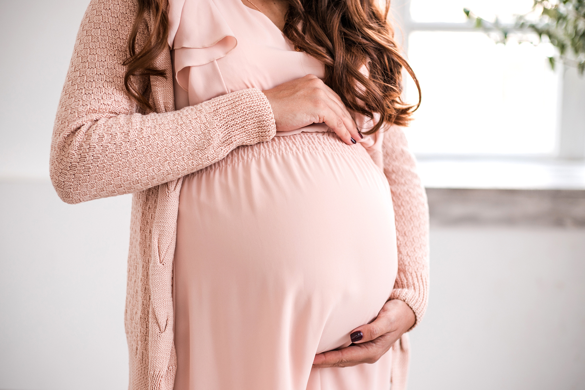 beautiful pregnant woman is holding belly close-up.
