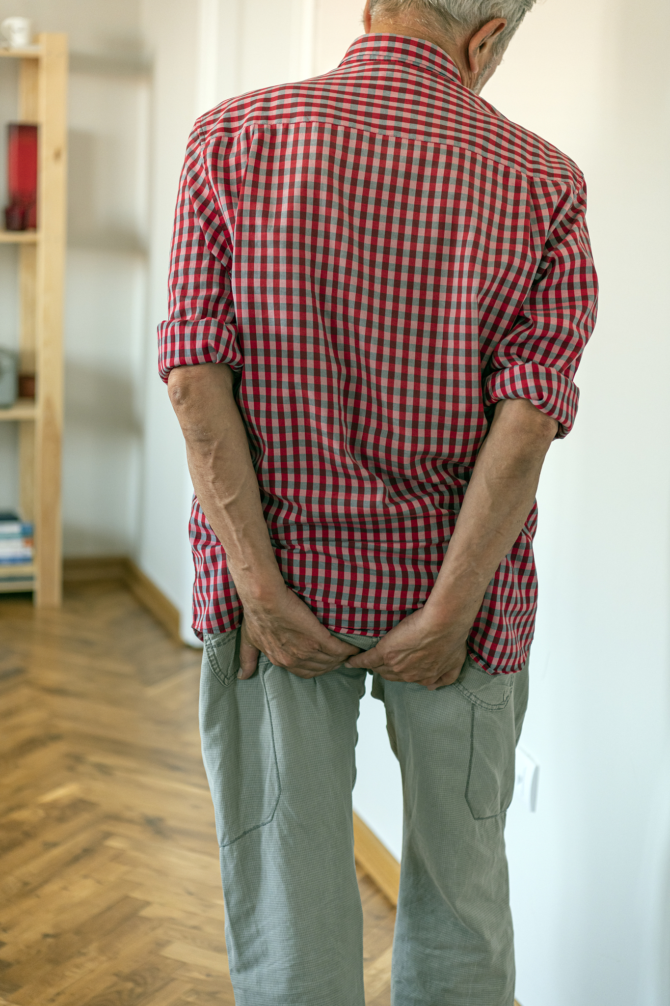 man with hemorrhoids holding his ass in pain