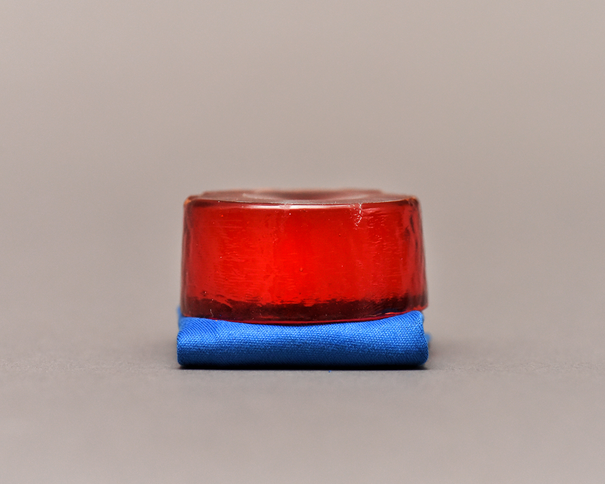 amber rosin and blue cloth isolated on grey background