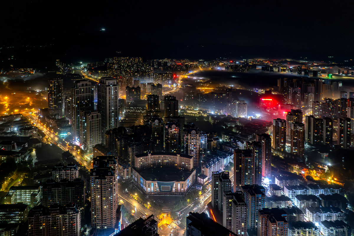夜间雾中城市建筑与灯光的鸟瞰图