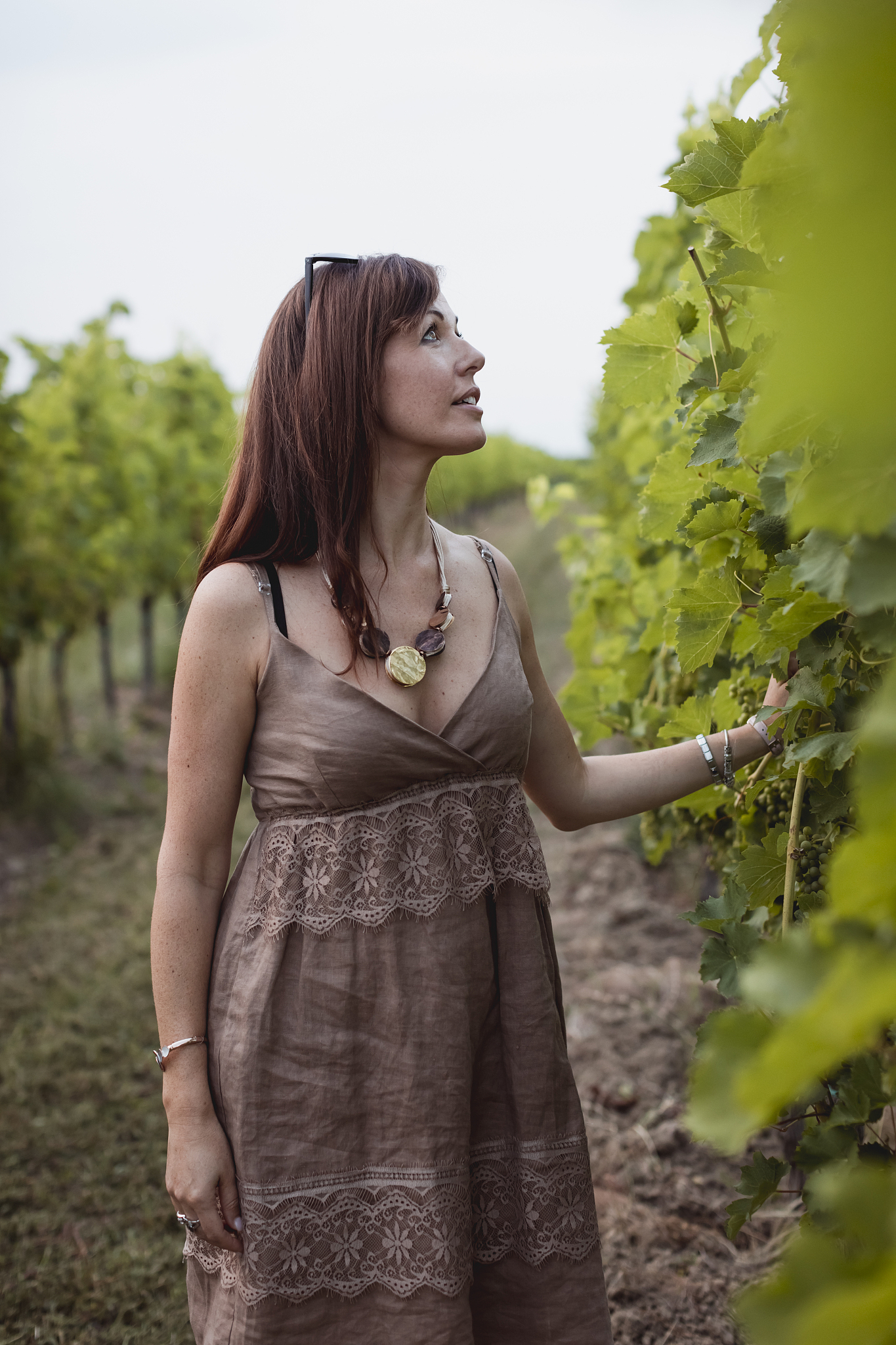 woman standing in vineyard, wearing summer dress