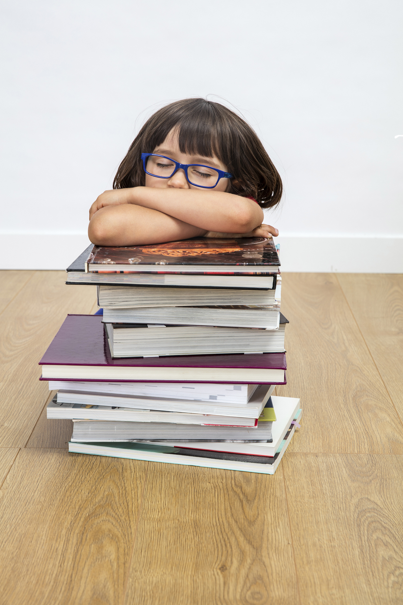 happy calm gifted child sleeping, lying on pile of books