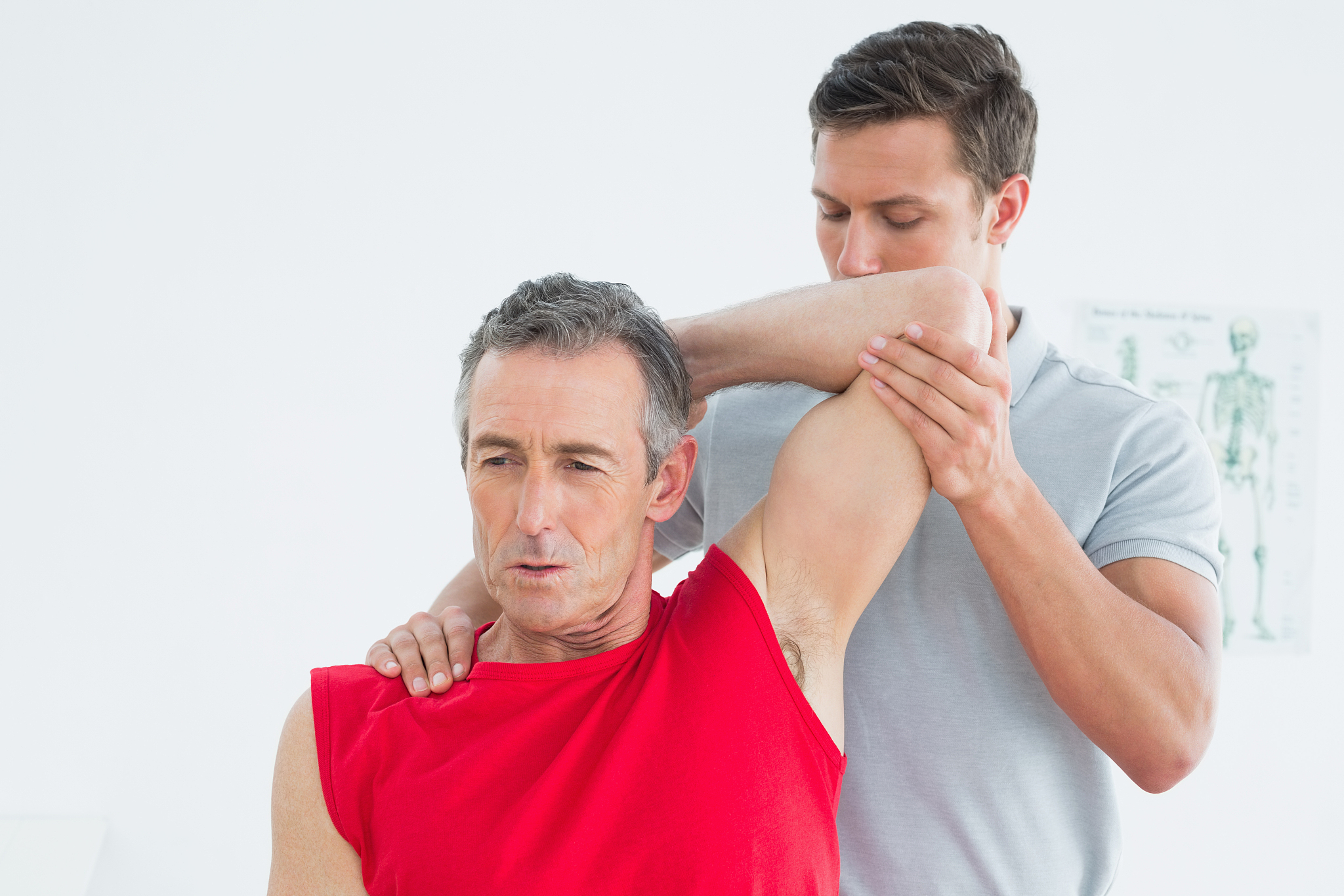 male physiotherapist stretching a mature mans arm