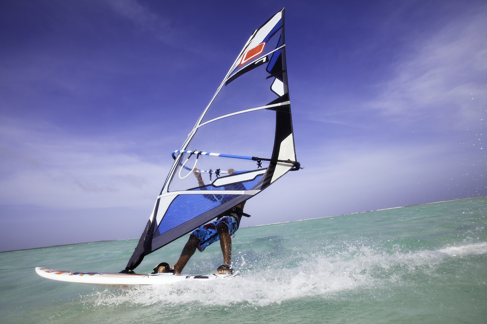 a windsurfer racing through the water.