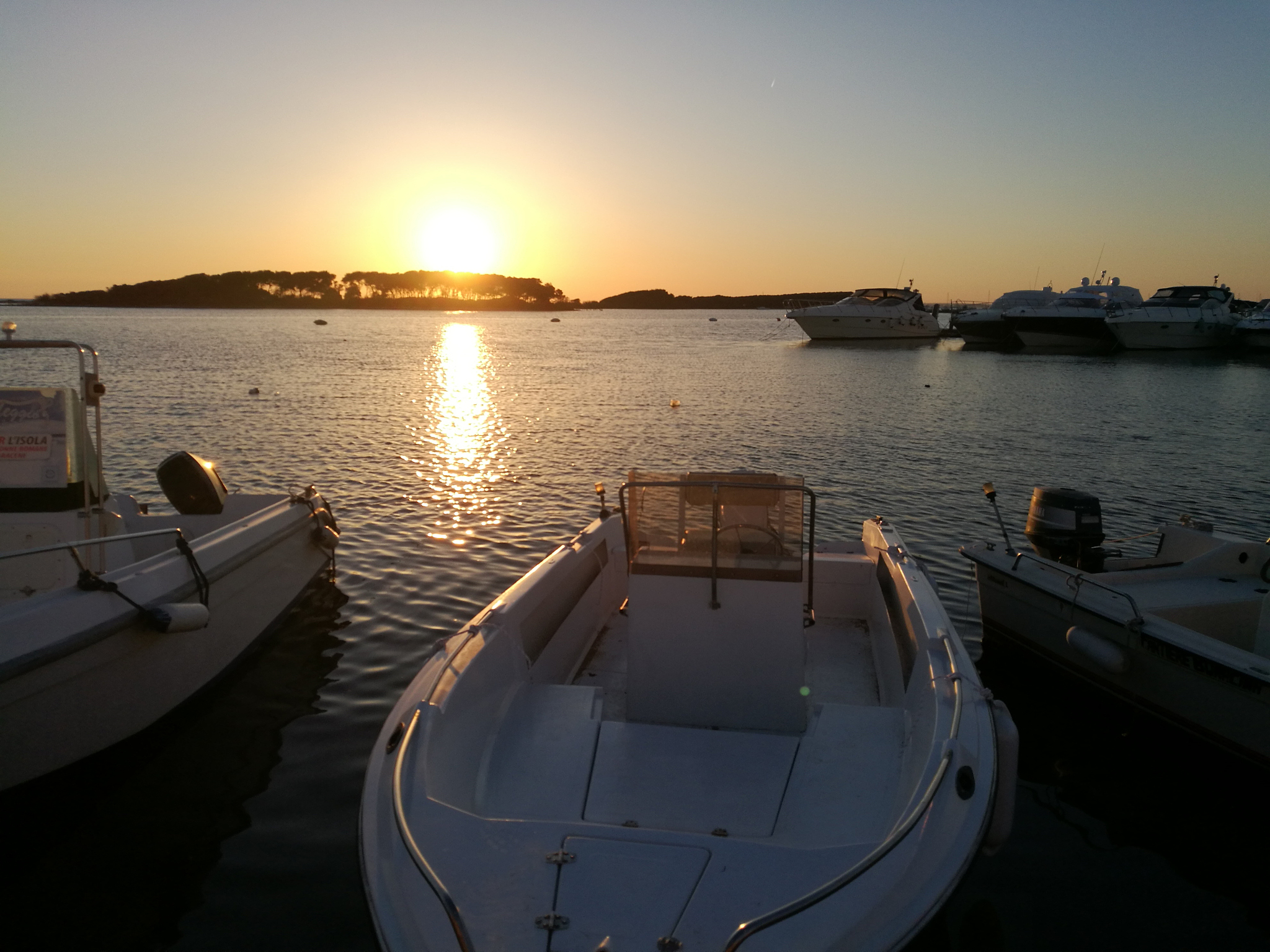 sailboats moored on sea against sky during sunset