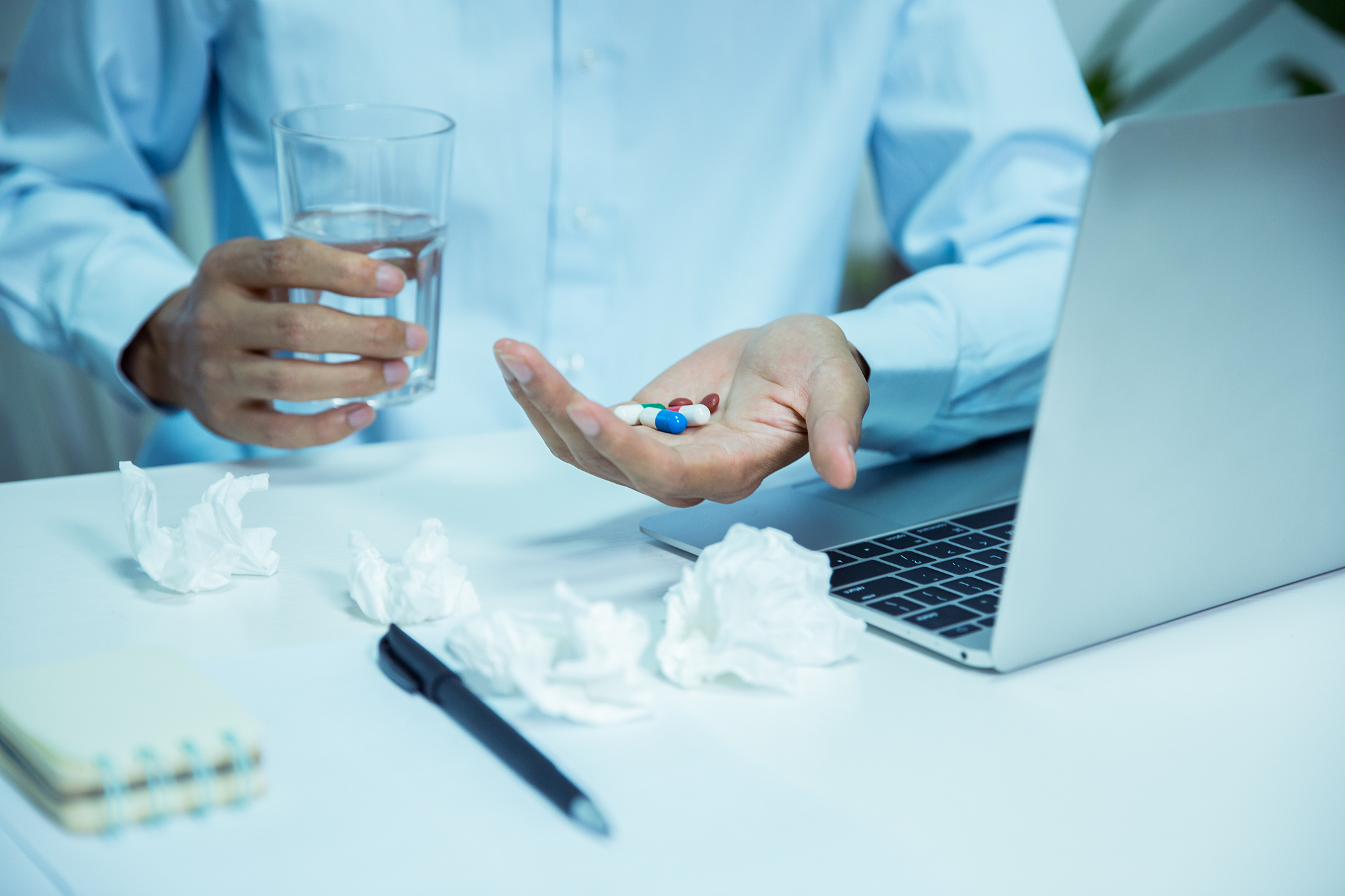 man taking pills in office