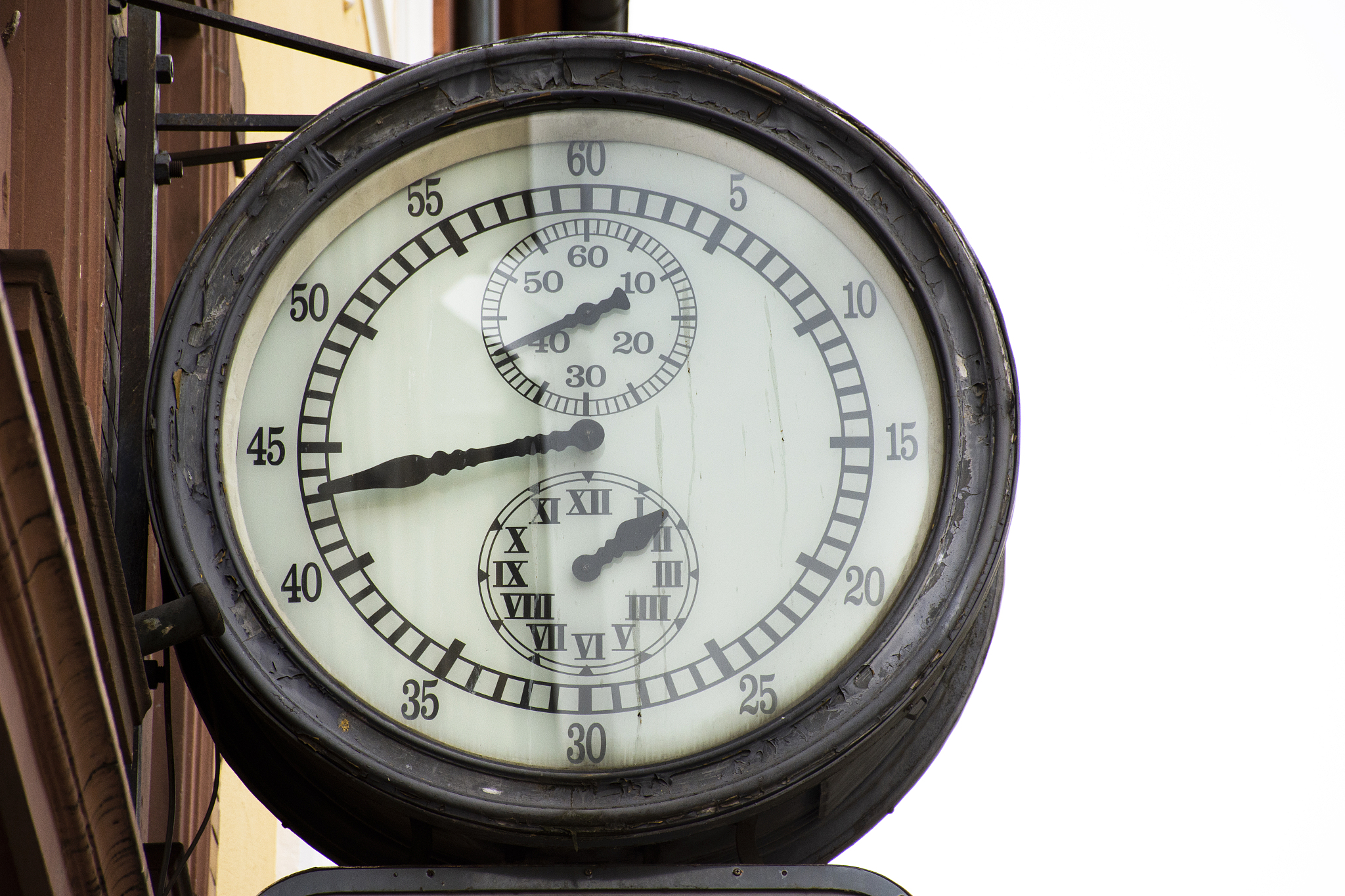 classic retro vintage metal clock hanging on front of building