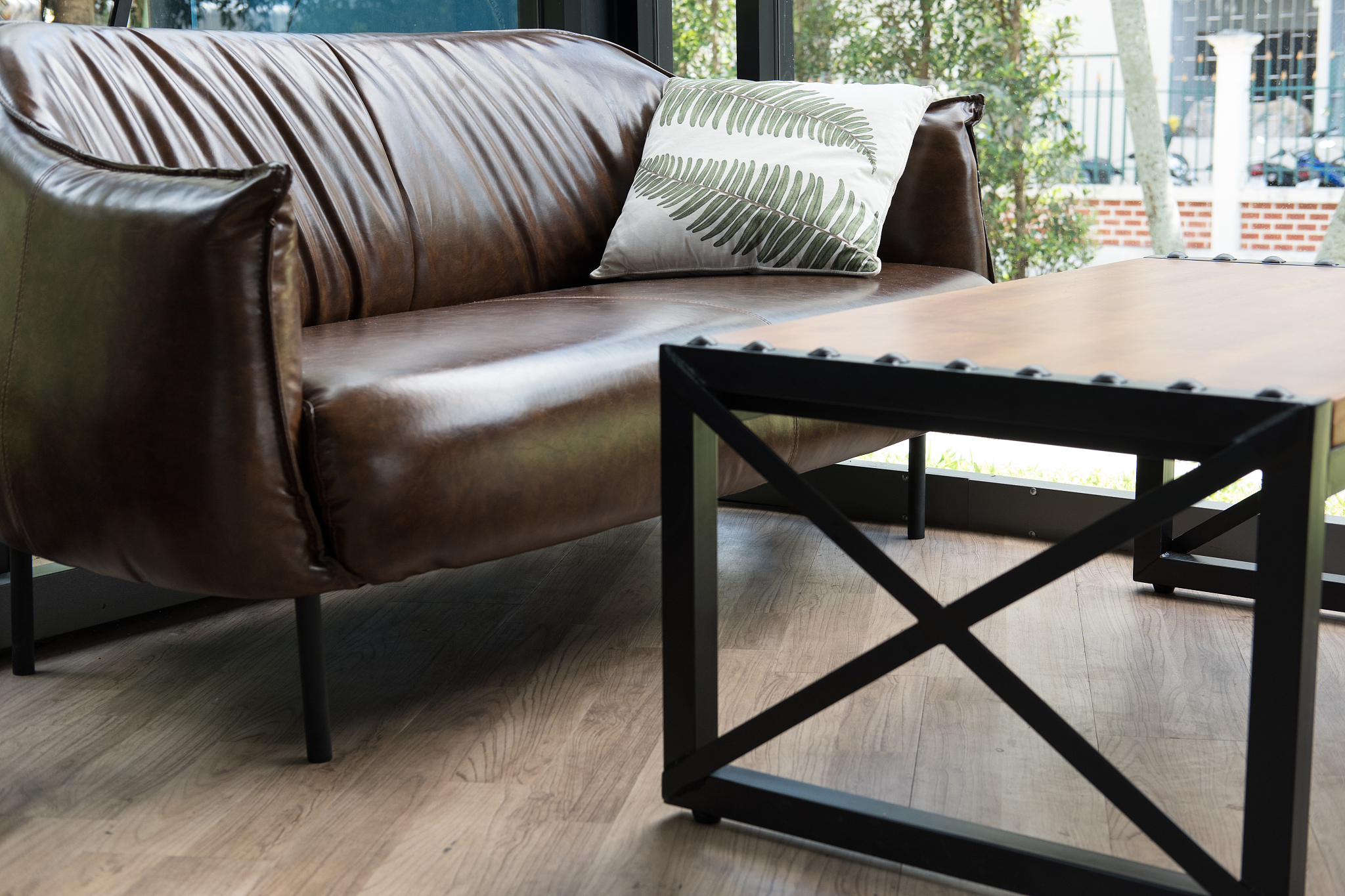 table, chair, brown leather sofa near window at restaurant or ca
