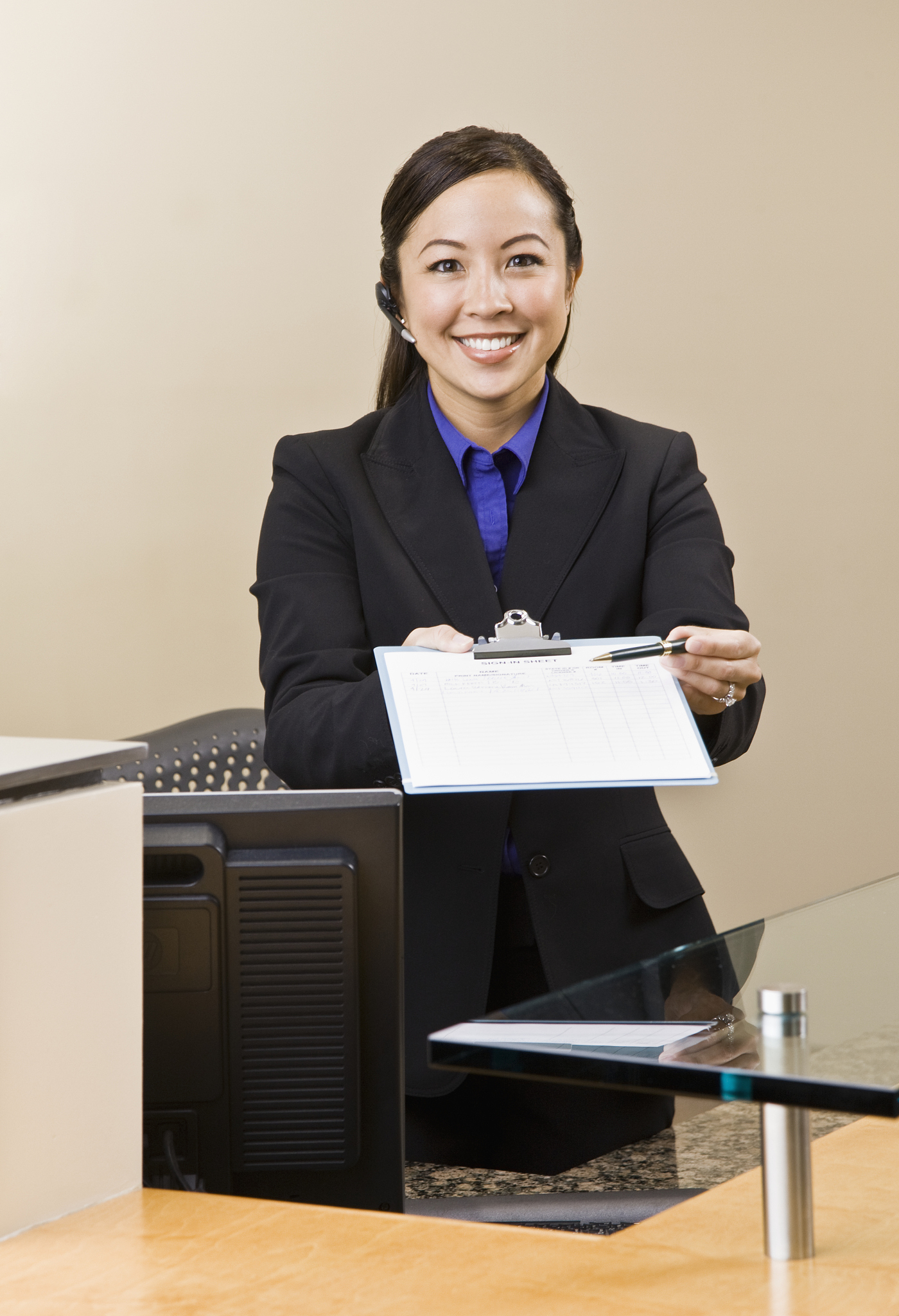 smiling receptionist holding clipboard