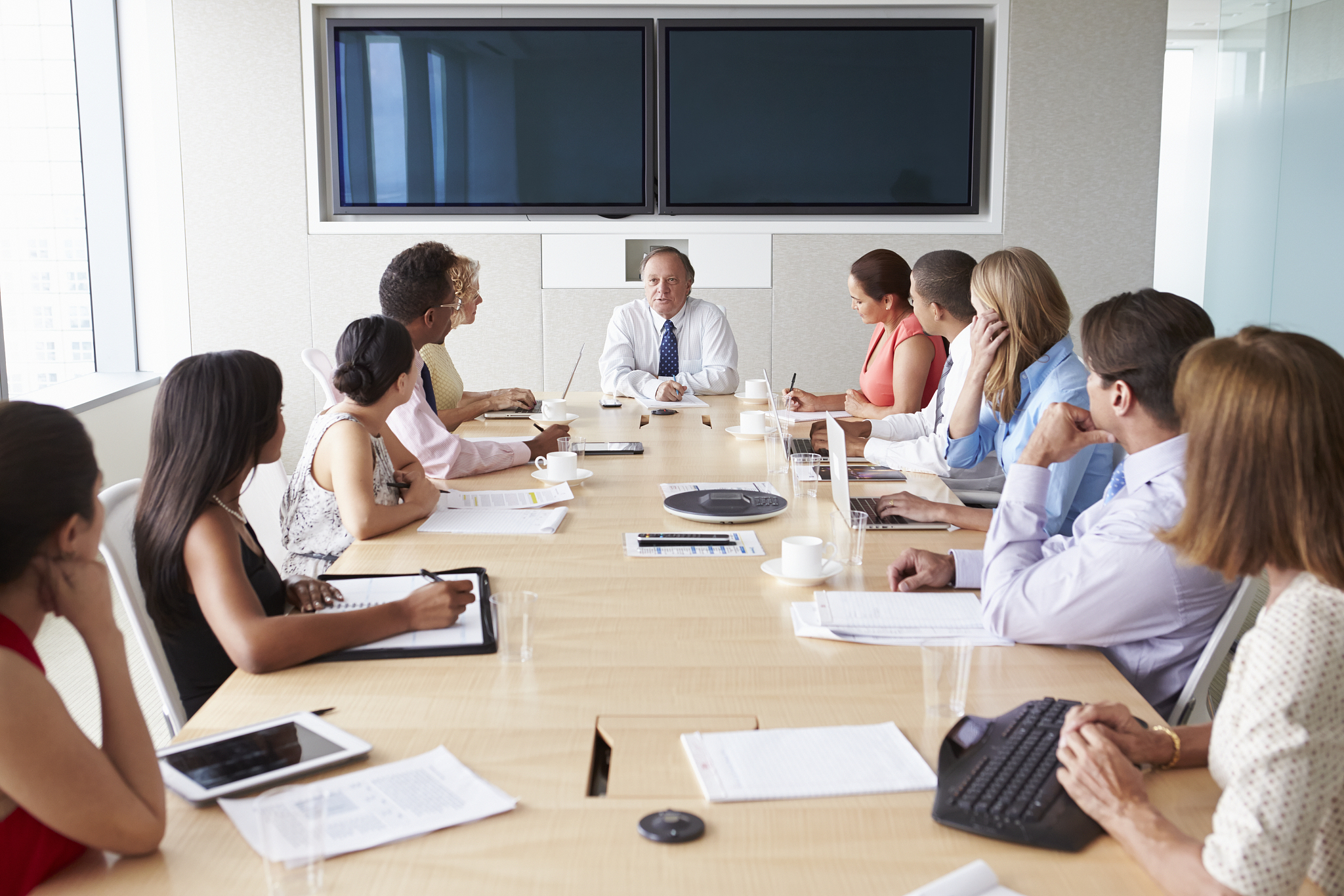 group of businesspeople meeting around boardroom table