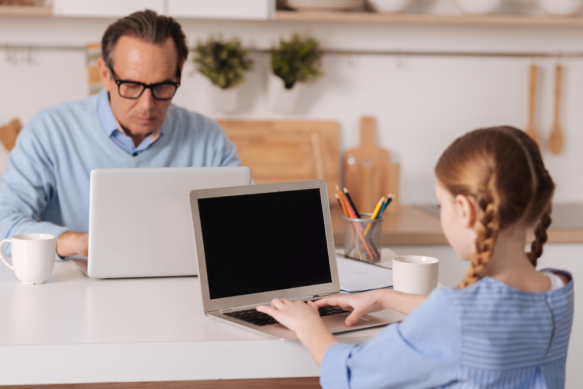 attentive aging man and kid surfing the internet at home