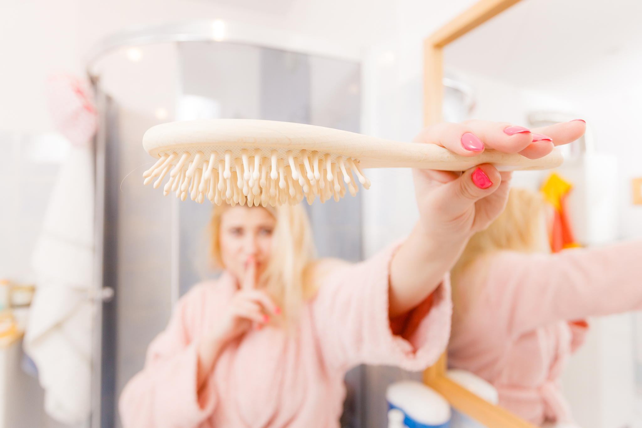 happy woman holding showing her hair brush