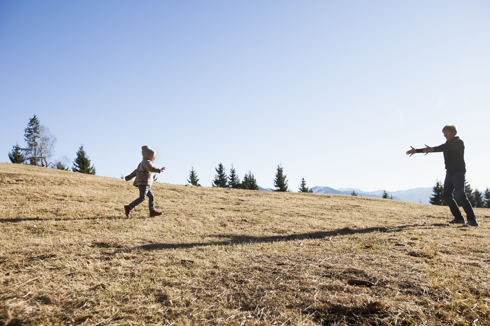 female toddler running to father on hill, tegernsee, bavaria, ge