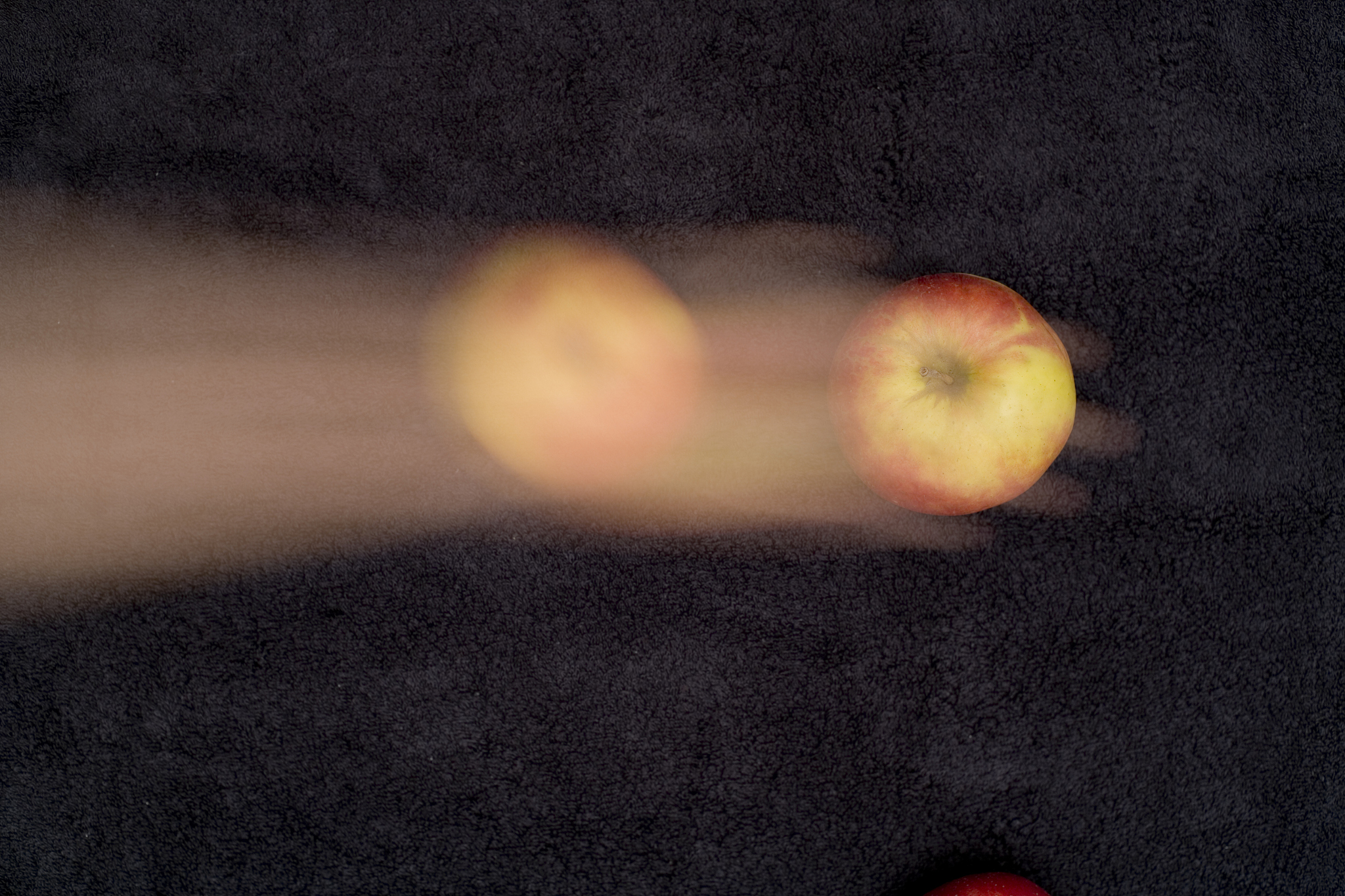 blurred motion of human hand holding apple