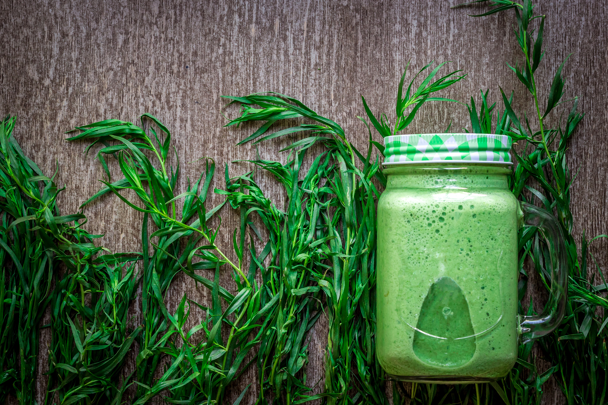 glass of spinach juice on wooden background