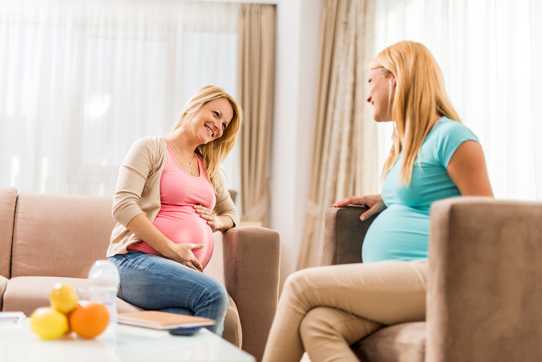 happy pregnant women enjoying together at home.