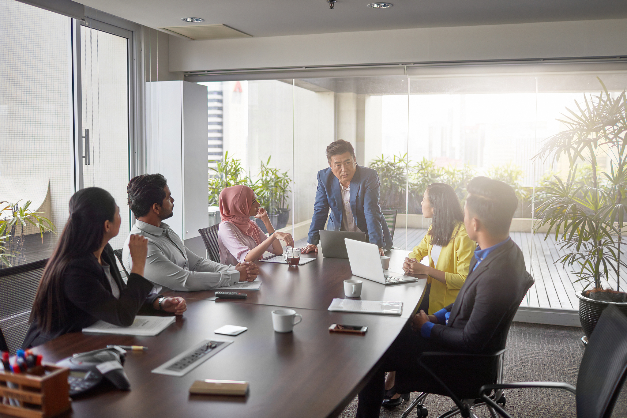 mature businessman explaining coworkers in meeting