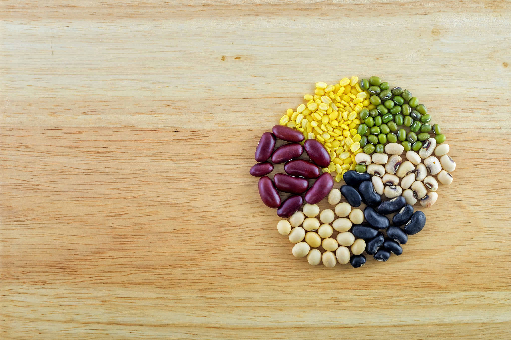 mixed beans on wood background.