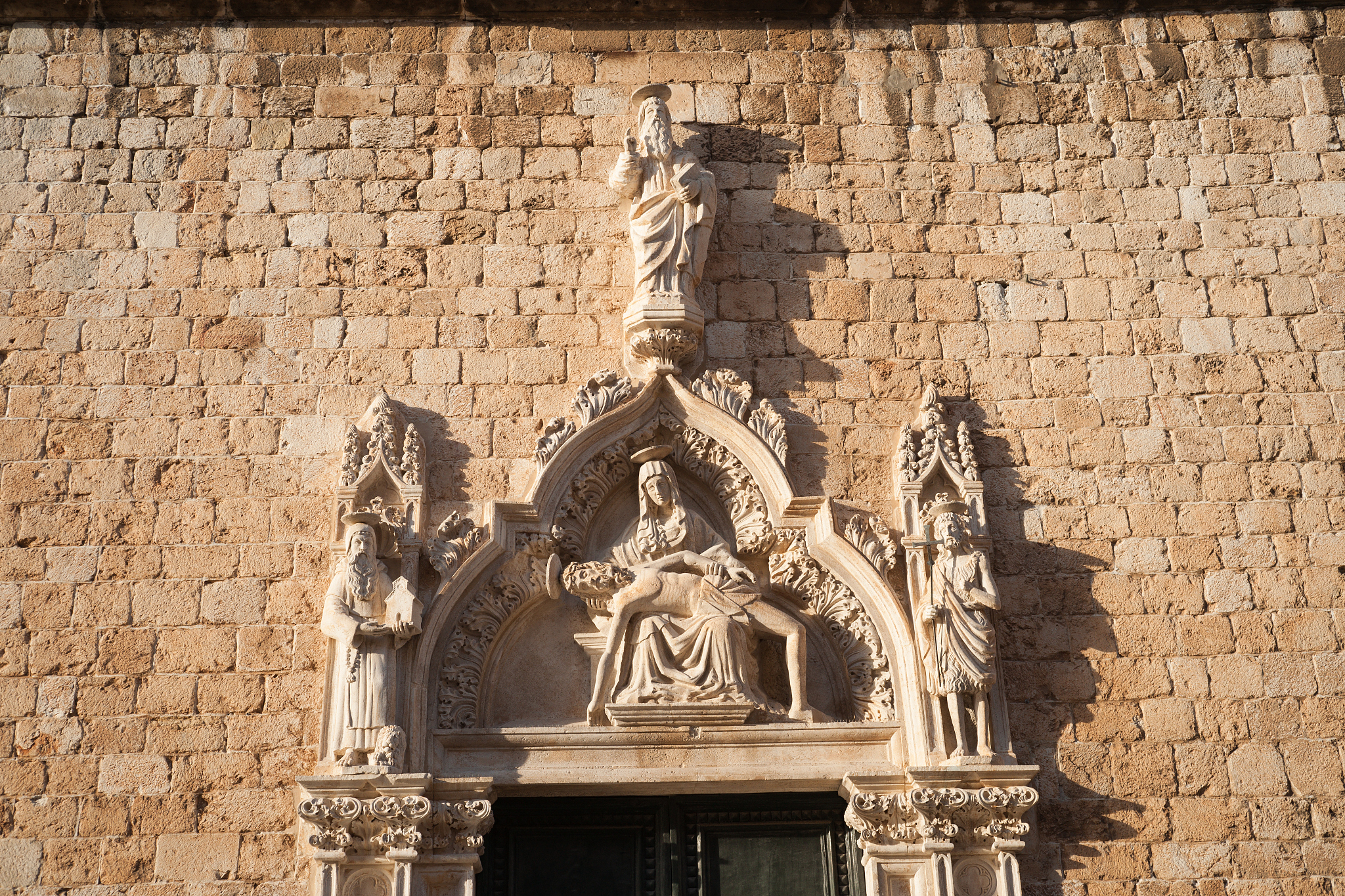 sculptures above the door of franciscan monastery