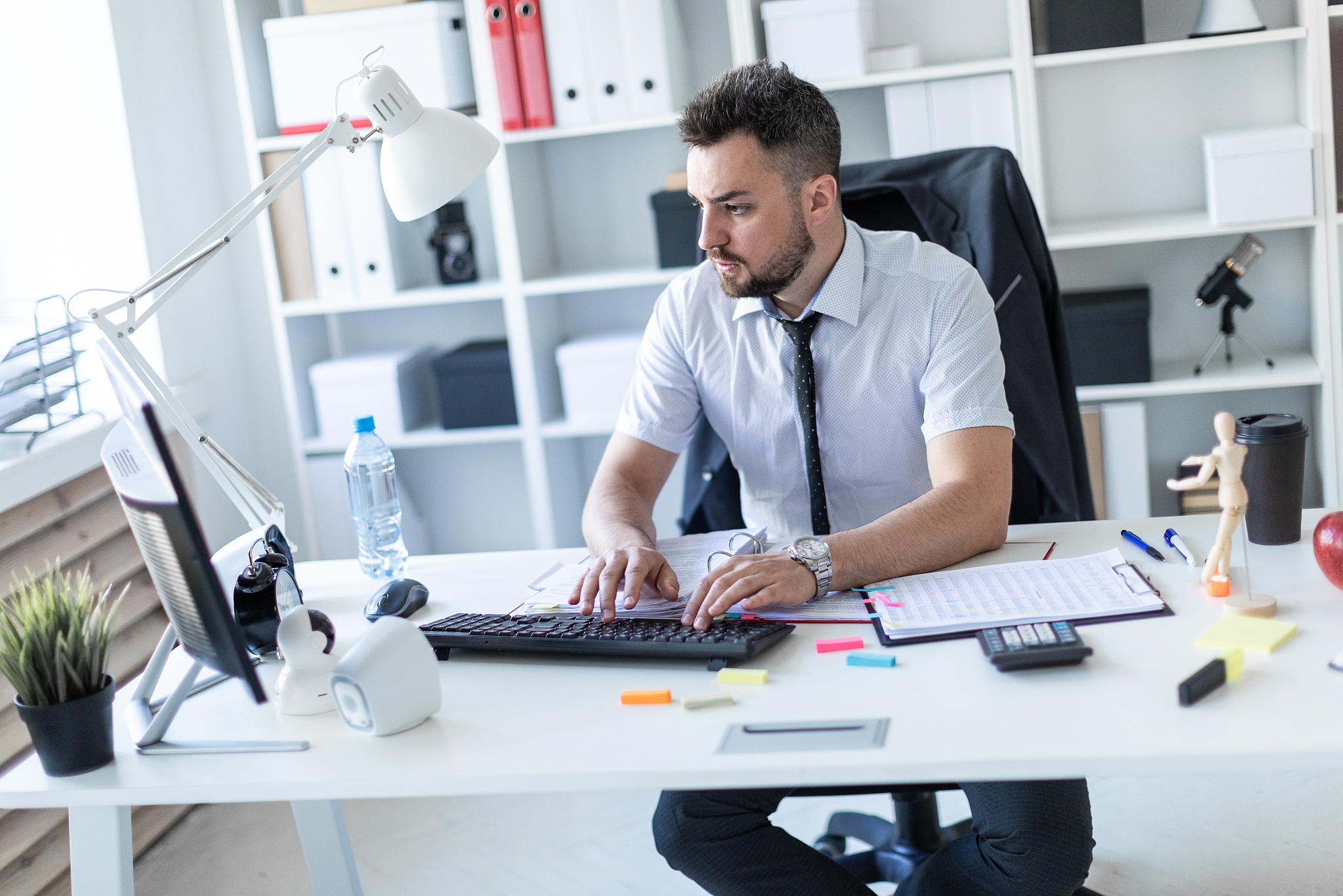 a man is sitting at a table in the office, working with document
