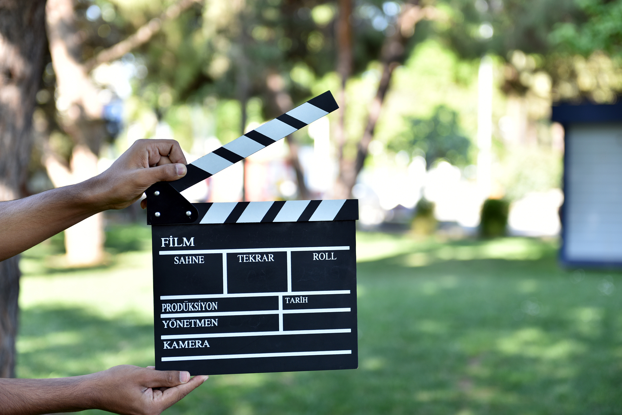 hands holding a movie and photo clapboard