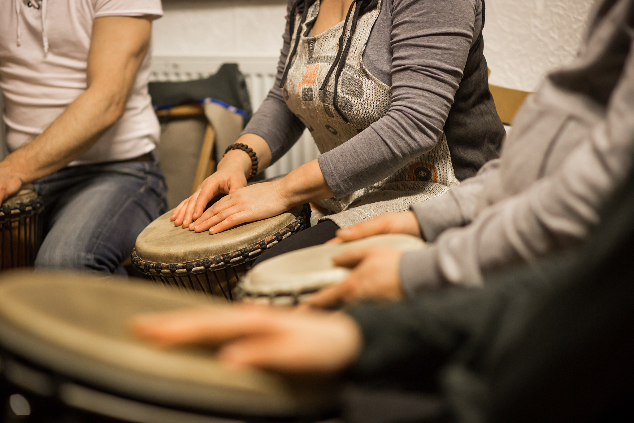 close up of hands on african drums, drumming for a music therapy