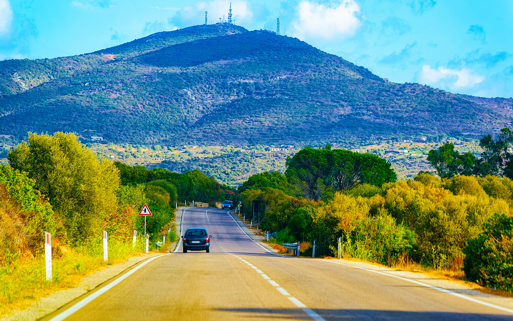 car on road in costa smeralda in sardinia island hills reflex