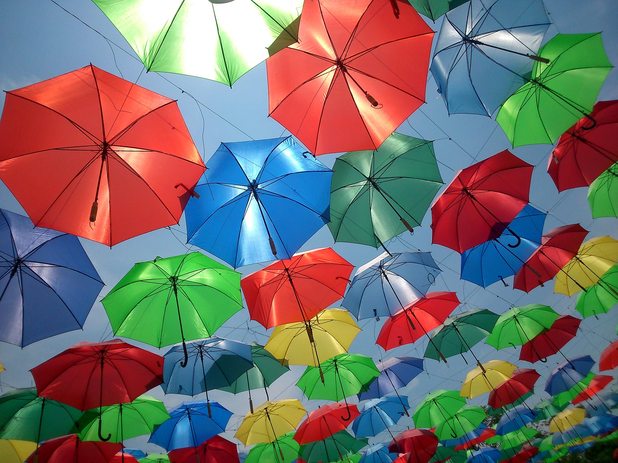 low angle view of multi colored umbrellas hanging against sky