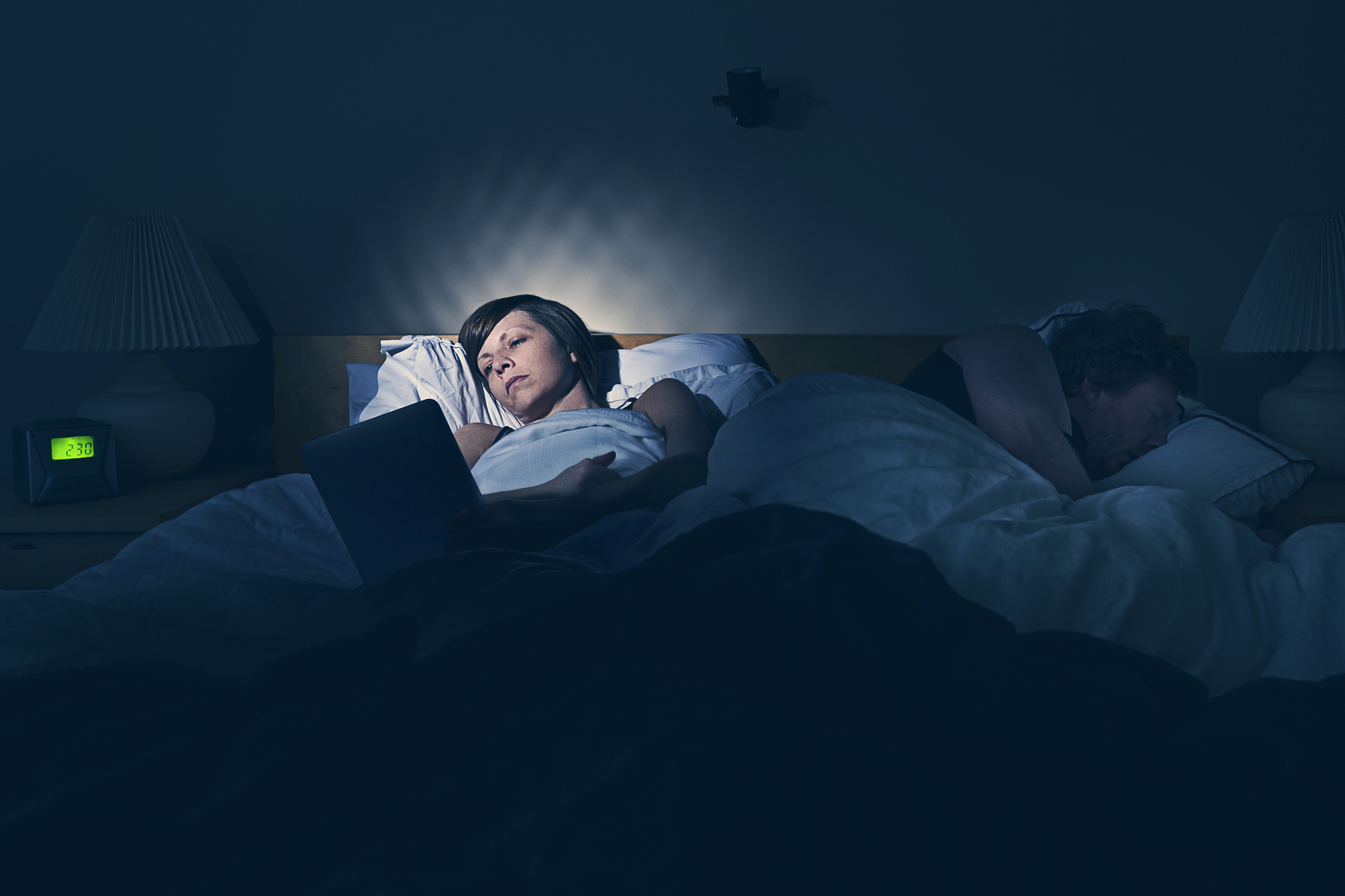 woman using tablet in bed